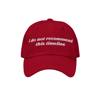 Red baseball-style cap with curved brim features I Do Not Recommend This Timeline in white embroidery, embodying Egoproof's b