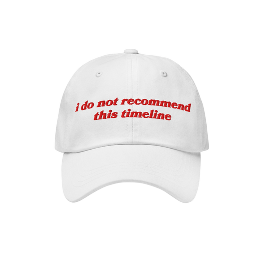 White cap with red embroidery reading i do not recommend this timeline, blending retro style with modern sarcasm. Ideal for e