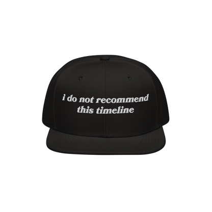 Black snapback cap with white embroidery reading I Do Not Recommend This Timeline, symbolizing modern chaos. Ideal for irony 
