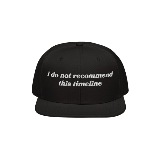 Black snapback cap with white embroidery reading I Do Not Recommend This Timeline, symbolizing modern chaos. Ideal for irony 