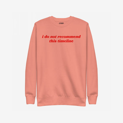 Timeline Sweatshirt EU with bold red italic text reading “i do not recommend this timeline” across the chest; a midweight crewneck for those embracing dry humor and societal critique.