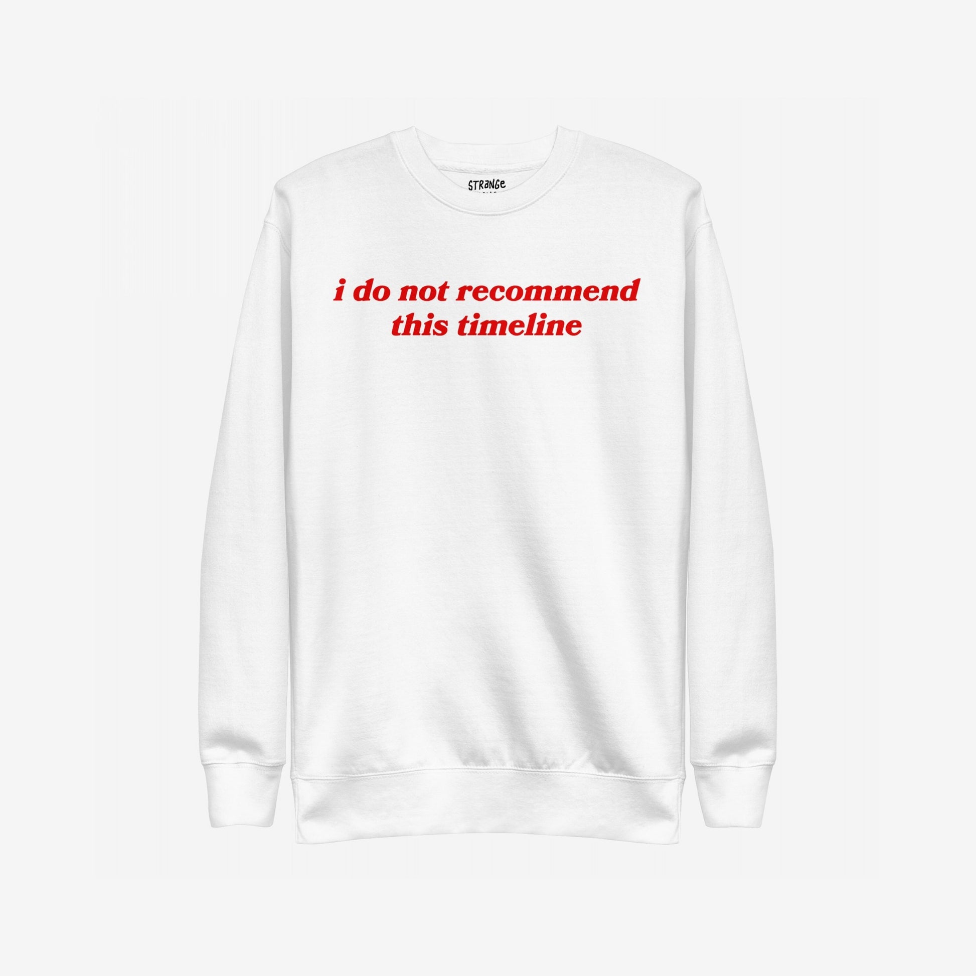 White long-sleeve crewneck sweatshirt with bold red text “i do not recommend this timeline” on chest, branded as Timeline Sweatshirt EU. It humorously highlights societal burnout, supporting mental health awareness through NAMI donations.