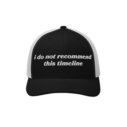 Black-and-white trucker cap with white mesh back. I Do Not Recommend This Timeline embroidered on front, merging retro style 